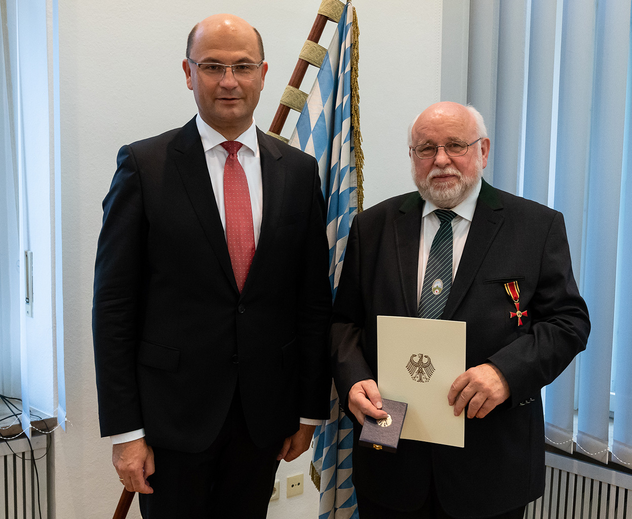 2. LSM Jürgen Sostmeier (re.) erhält aus den Händen von StMin Füracker das Bundesverdienstkreuz am Bande