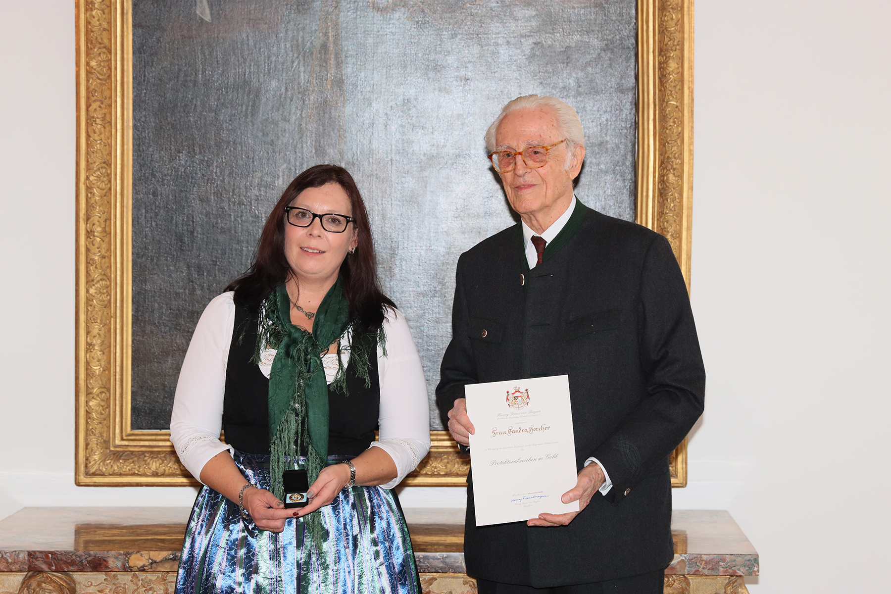 Sandra Horcher (Rattelsdorf) erhält aus der Hand des Herzogs Franz von Bayern (Mitte) das Protektoratsabzeichen in Gold.