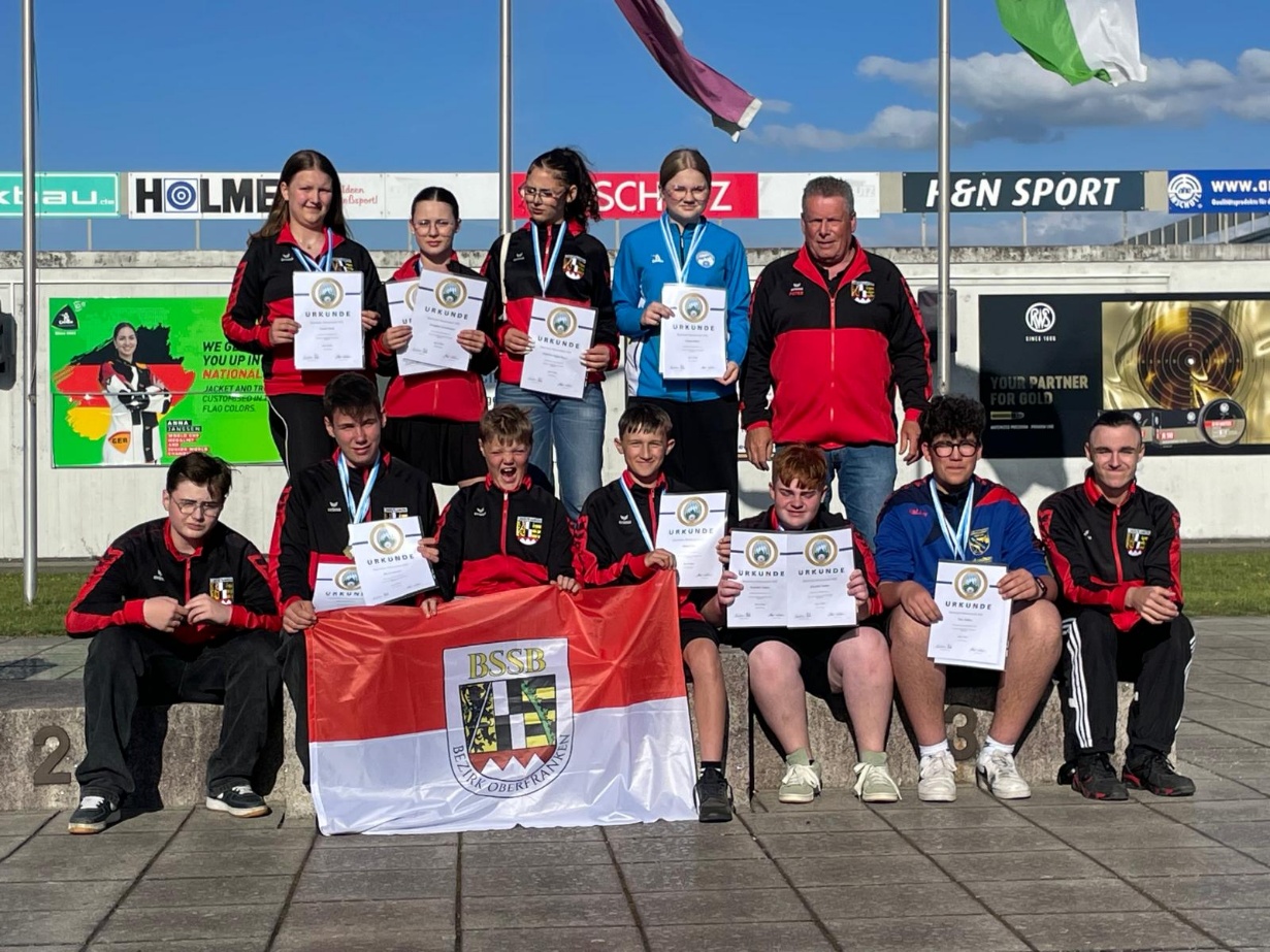 Die Erfolgstruppe Pistole 2026 mit L. Heim (Kronach), J. Gründonner (Stadtsteinach);Ch. Bayer (Speichersdorf), E. Kalter (Neustadt b. Co), Trainer P. Baldauf [o.] und N. Wiesmüller, O Großmann, P. Schiller, S. Lorz, B. Schürr, M. Müller & J. Nitschke [u.]
